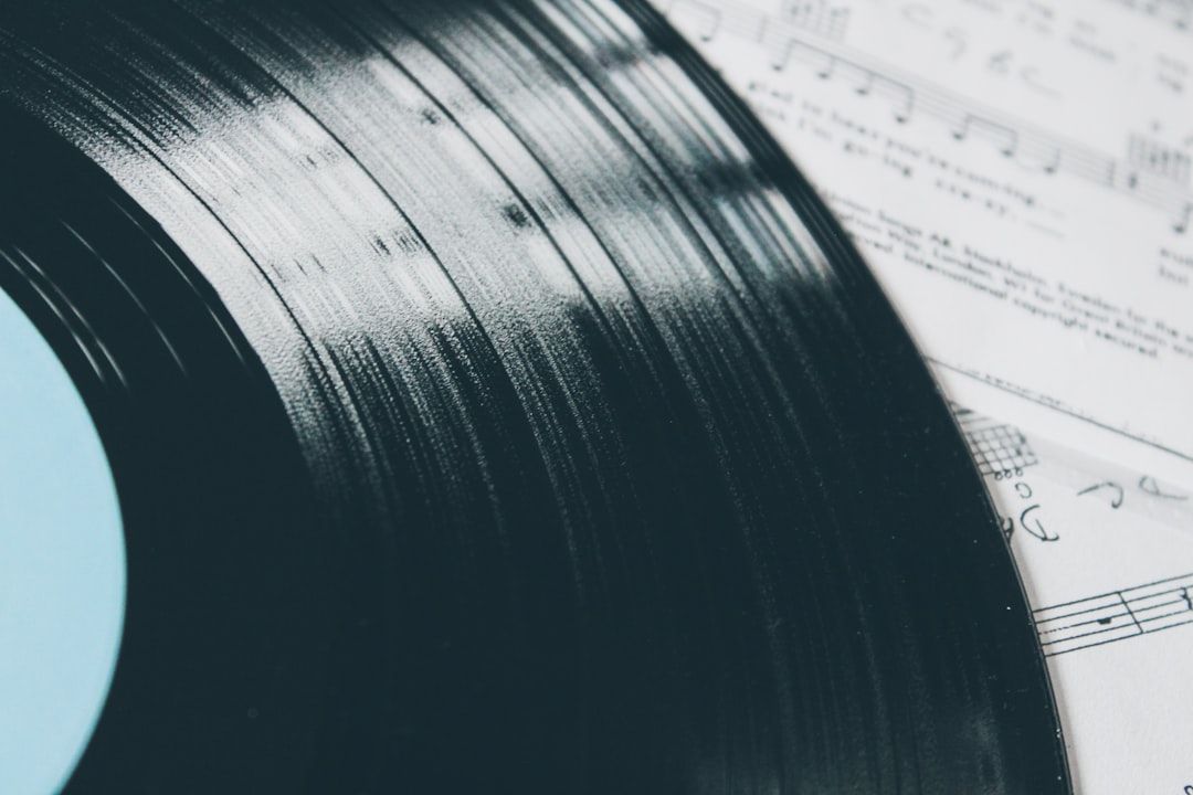 Vinylskiva och notblad, symboliserande musikaliska tillgångar och komposition.
